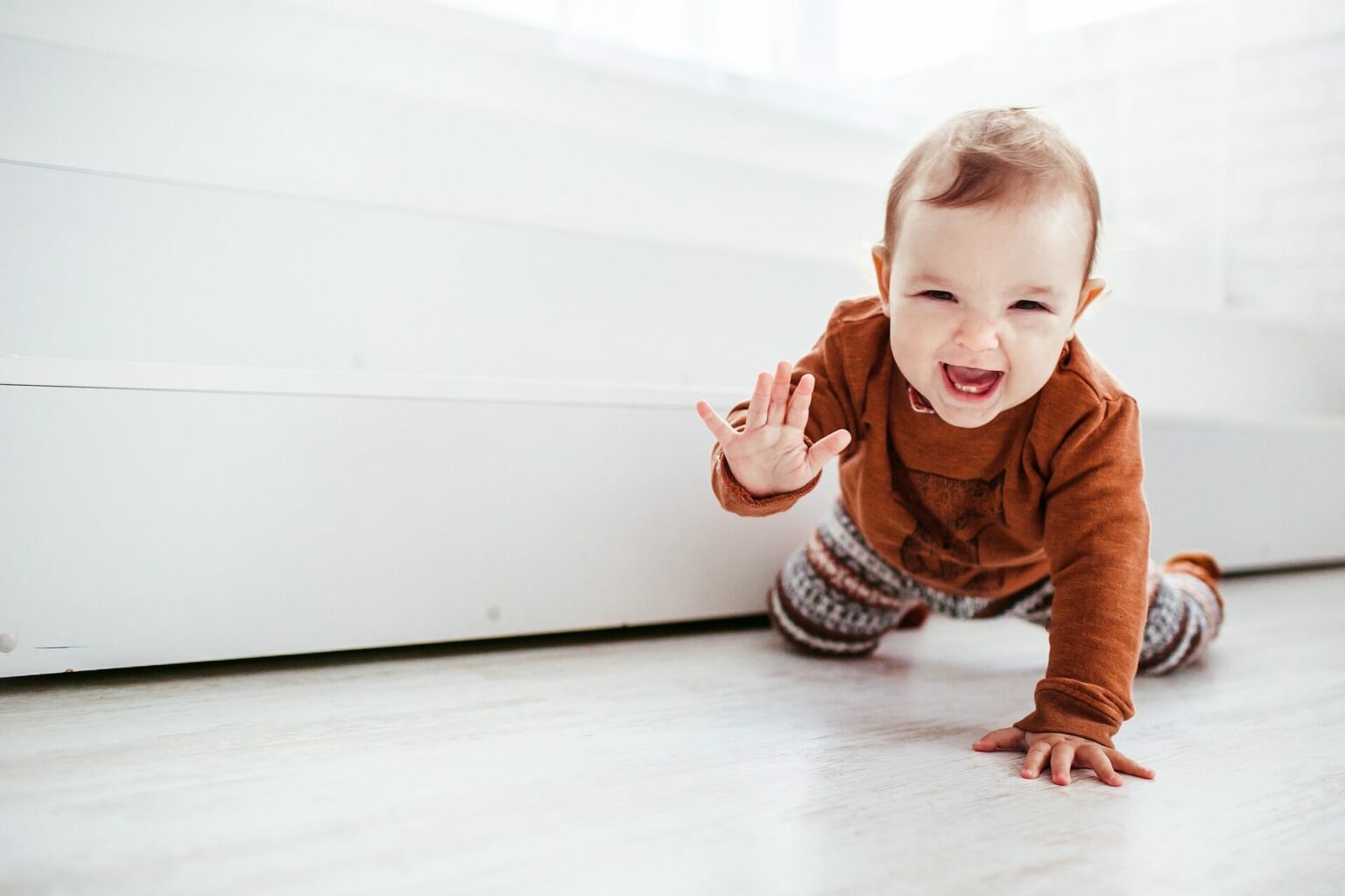 Happy baby crawling towards a baby yoga class