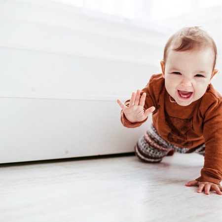Happy baby crawling towards a baby yoga class